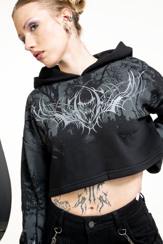 Zwarte crop hoodie met grafische print van een bos en demonische kop. Model draagt de hoodie.