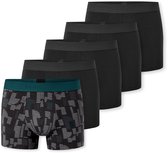 Vijf boxershorts. Eén op de voorgrond heeft een zwart-grijs gemêleerd patroon en een donkergroene band. Vier andere, effen zwarte boxers, staan erachter.
