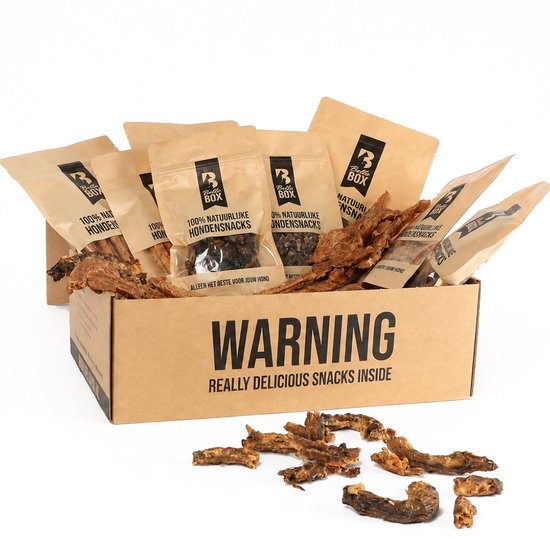 Een open kartonnen doos gevuld met verschillende zakjes Bellobox hondensnacks en veel gedroogde snacks eromheen.