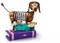LEGO Slinky Hond opgestapeld op paarse en blauwe LEGO boeken met Woody en een kleine hond.