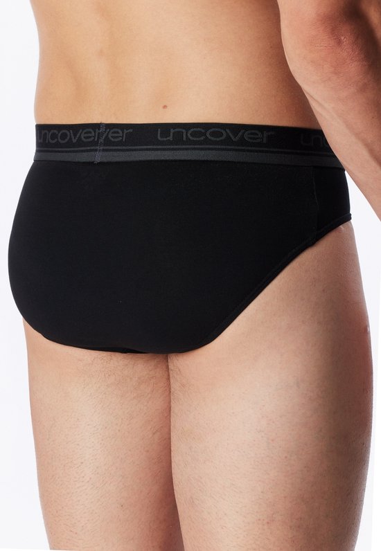 Achterkant van een zwarte slip met grijze band met UNCOVER-logo.