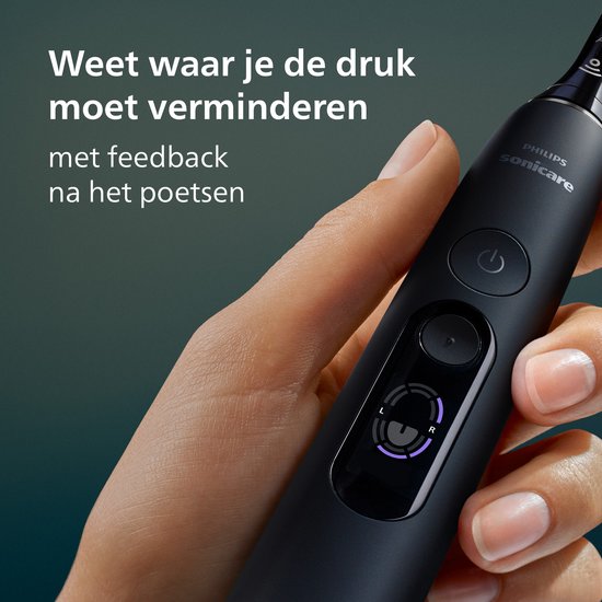 Hand die een zwarte Philips Sonicare tandenborstel vasthoudt met een paars display.