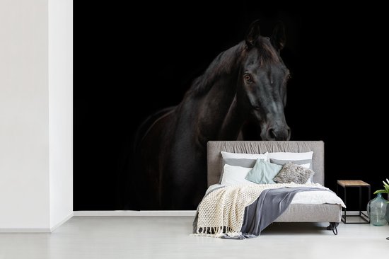Slaapkamer met fotobehang van een zwart paard tegen een zwarte achtergrond achter een grijs bed.