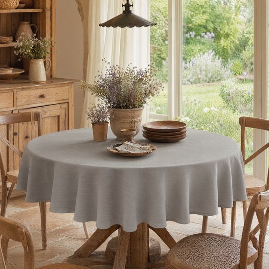 Nappe grise aspect lin sur une table en bois avec fleurs séchées et vaisselle.