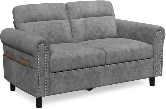 Grijze tweezitsbank met zilveren decoratieve spijkers, opbergvakken aan de zijkant en zwarte pootjes.