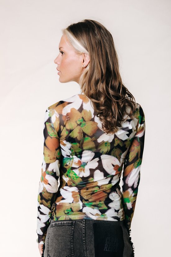 Model van achteren gezien in een nauwsluitende top met lange mouwen en een bloemenprint in bruin, groen en wit.