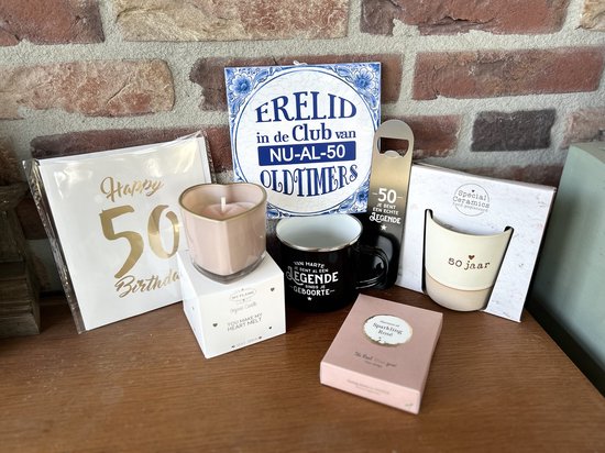 Feestelijke cadeautjes voor 50 jaar: kaarten, hartvormige kaars, mok, opener, tegeltje en kaars. Gouden 50 op kaart.