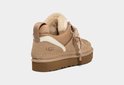 Beige UGG sneaker met witte accenten, bont voering en bruine zool.