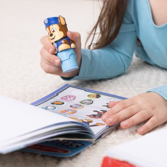 Kind met PAW Patrol Chase stickerstempel boven een stickerboek.