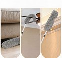 Grijze microvezel plumeau wordt gebruikt om een bank, plafondventilator en muur schoon te maken.