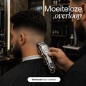 Een barbier trimt een man met een zilverkleurige Royce tondeuse.