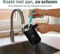 Hand wordt geholpen bij het schoonmaken van de zwarte melkopschuimer met een blauwe borstel onder de kraan. Tekst: "Koekt niet aan, zo schoon. Even afspoelen met de meegeleverde borstel."