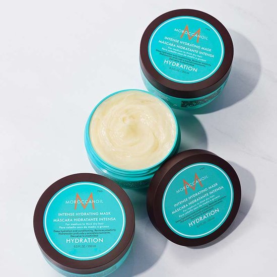 Drie potten Moroccanoil Intense Hydrating Mask. Eén pot is open met crème erin. De potten zijn bruin met turquoise labels.