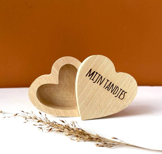 Houten hartvormig bewaardoosje, open met deksel met 'MIJN TANDJES', naast een takje.