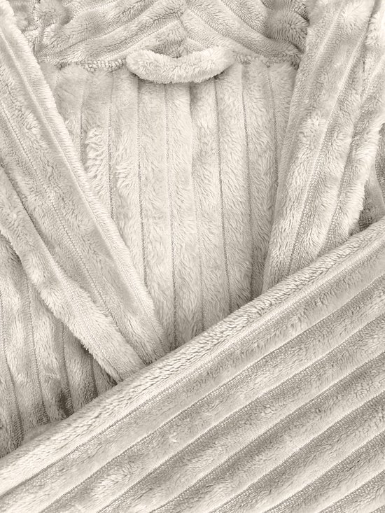 Gros plan sur le tissu polaire teddy côtelé crème d'un peignoir.