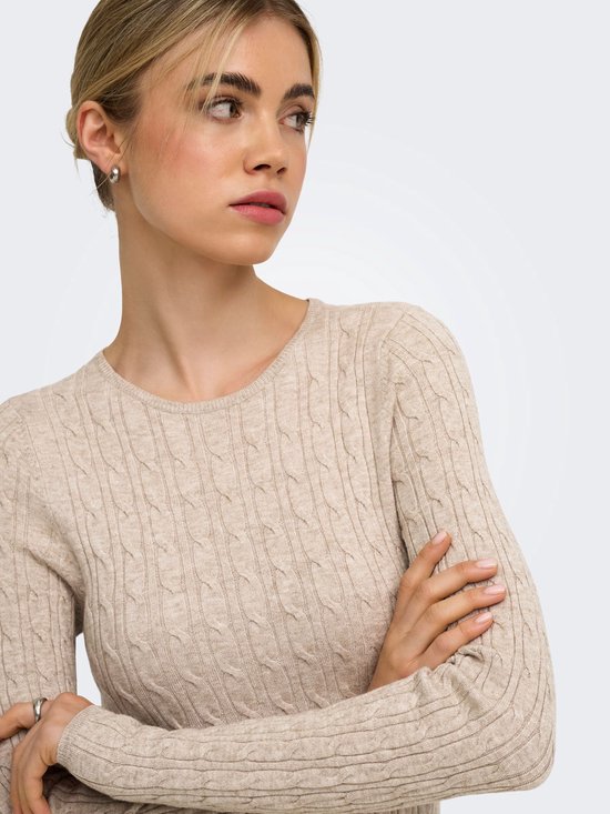 Close-up van model met beige gebreide jurk met kabelpatroon.