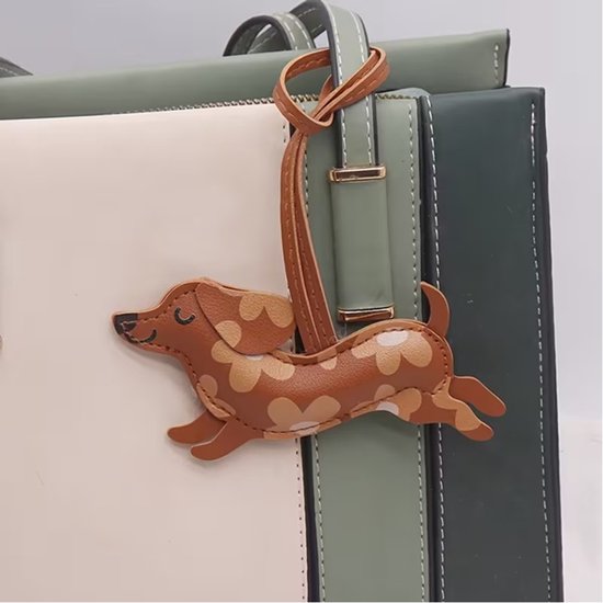 Porte-clés teckel marron à motif floral, attaché à un sac de luxe.