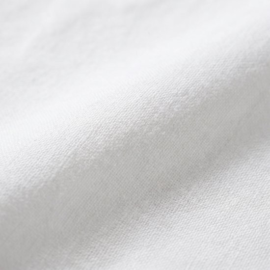 Close-up van een witte geweven katoenen stof met subtiele textuur.