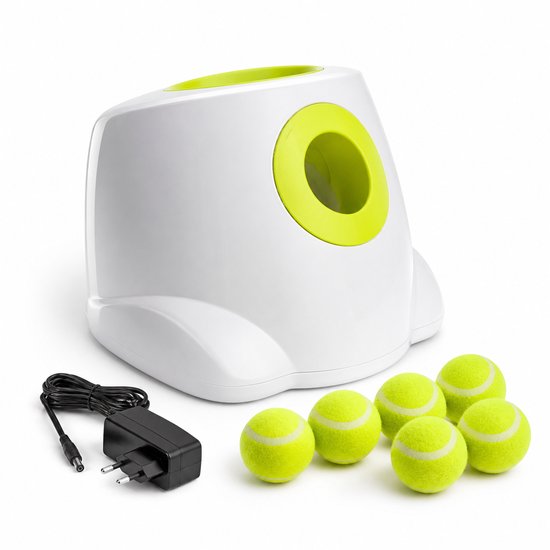 Witte automatische ballenwerper met groene opening, samen met zes tennisballen en een adapter.