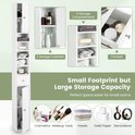 Witte smalle badkamerkast met 2 deuren, 1 lade en 5 opbergvakken. Toont cosmetica, make-up, handdoeken, toiletpapier en decoraties.