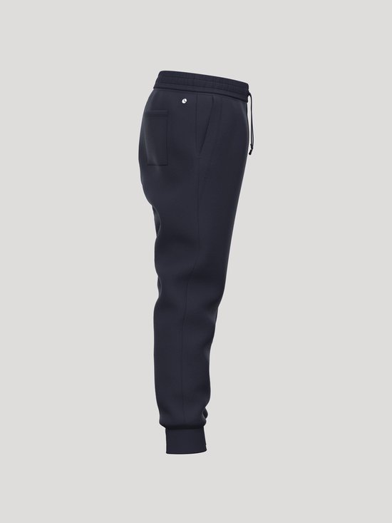 Zijaanzicht van een donkerblauwe joggingbroek met elastische tailleband, trekkoord en een achterzak.
