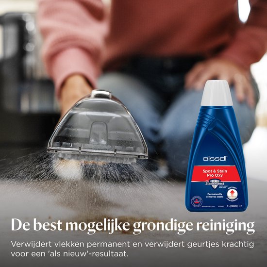 Een BISSELL SpotClean Pro Oxy fles met een schoonmaakapparaat dat stoom op een vlek spuit.