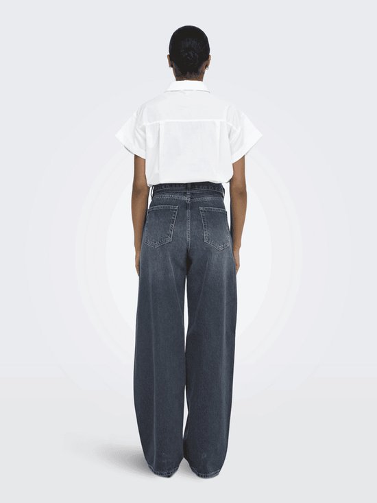 Model met de rug naar ons toe, draagt een witte blouse en wijde, grijze jeans. De jeans heeft een hoge taille en een verfijnde wassing.