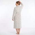 Vrouw staand, rug naar de camera, in een zachte, lange, beige badjas met panterprint.