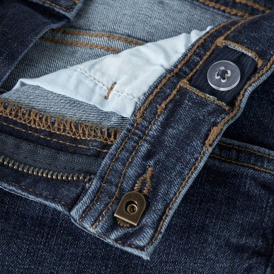 Detail van de tailleband van een donkerblauwe spijkerbroek, met knoop, rits en verstelbare tailleband.