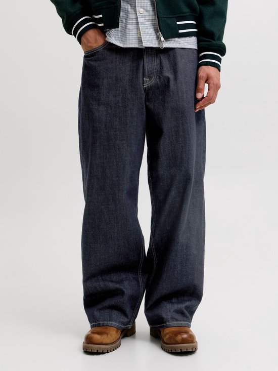 Close-up van een wijde, donkere jeans met contrasterende stiksels op de zakken en broekspijpen.