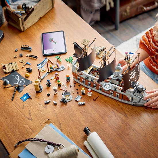 Bouw van LEGO Garp's Marine Battleship op een houten tafel, met onderdelen en een tablet.