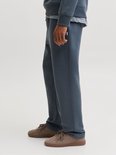 Close-up van een man in donkerblauwe joggingbroek, sneakers.