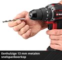 Een hand die een metaalboor houdt, de andere hand op de metalen 13 mm snelspanboorkop van een rode en zwarte boormachine.