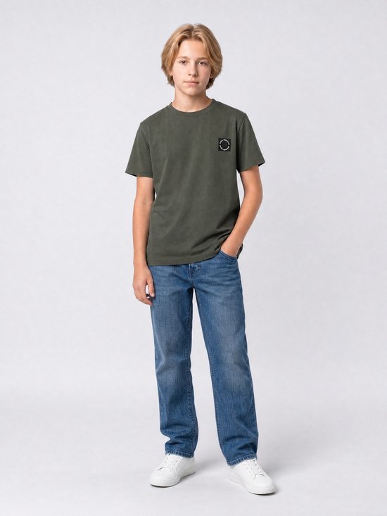Jongen in donkergroen T-shirt met 'PETROL INDUSTRIES' logo en blauwe jeans.