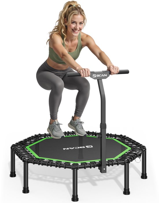 Vrouw in sportkleding doet een squat op een zwarte trampoline met groene rand en T-handvat.