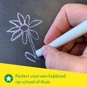 Een hand tekent met wit krijt een bloem op een krijtbord. 'Perfect voor een krijtbord op school of thuis'.