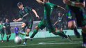 Voetbalwedstrijd in actie. Speler met nummer 8 in zwart-groen tenue dribbelt de bal langs een tegenstander.