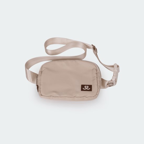 Beige heuptas met label, verstelbare band en gespsluiting.