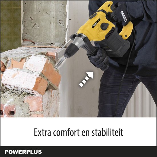Gele klopboormachine met extra handvat, in gebruik bij het afbreken van een bakstenen muur. Tekst: 'Extra comfort en stabiliteit'.