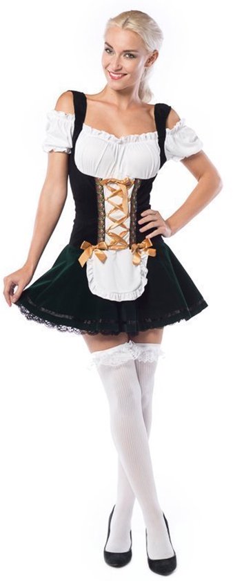 Femme portant une robe dirndl noir et blanc avec une jupe verte, un tablier blanc et des bas blancs. La robe a un style corset avec laçage.