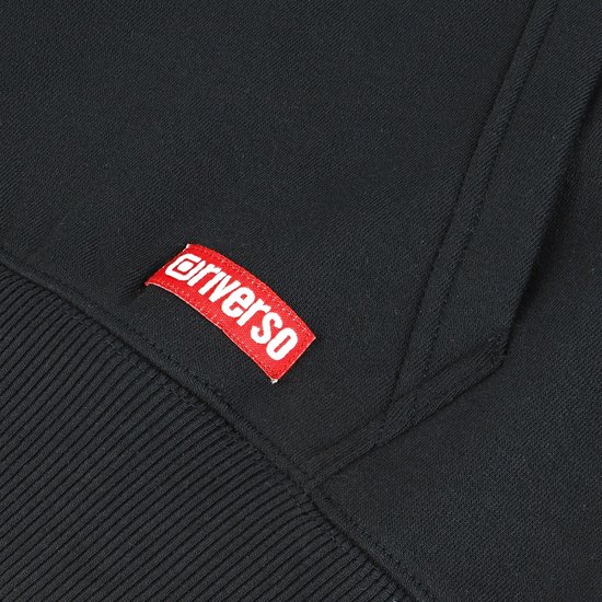 Detail van een rode Riverso label op een zwarte hoodie.