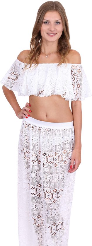 Model draagt een witte, kanten off-the-shoulder crop top en bijpassende witte kanten maxirok.
