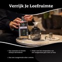 Vrouw vult een glazen diffuser met geurolie uit een fles "Belle Vie" met "Scentchips" logo.