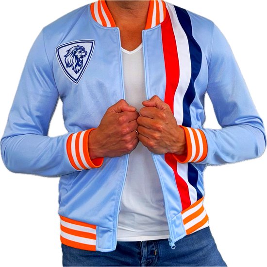 Man met lichtblauwe retro trainingsjas, voorzien van oranje, witte en marineblauwe strepen en leeuw embleem op de borst.