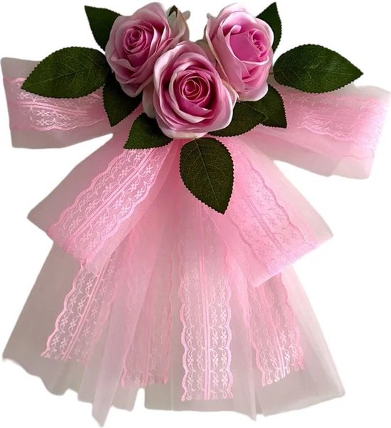 Roze strik versierd met kunstbloemen en kant, bevestigd aan autospiegels.
