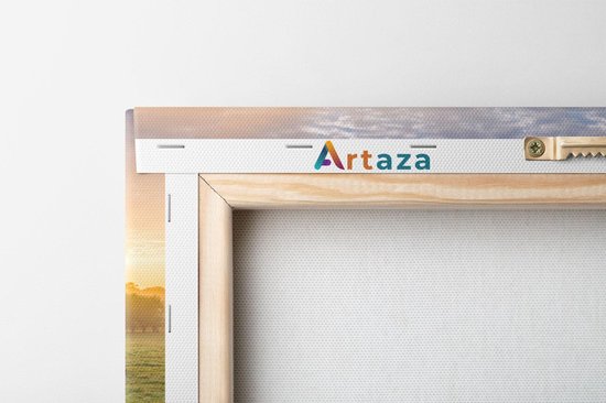 Achterkant van een Artaza canvas met houten frame en ophanghaakje, met een deel van de zonsopgang in de wei zichtbaar.
