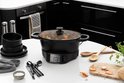 Zwarte Russell Hobbs multicooker met deksel op een witte tafel, met stoofpot erin.