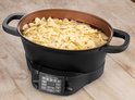 Zwarte multicooker met farfalle pasta die kookt in water.