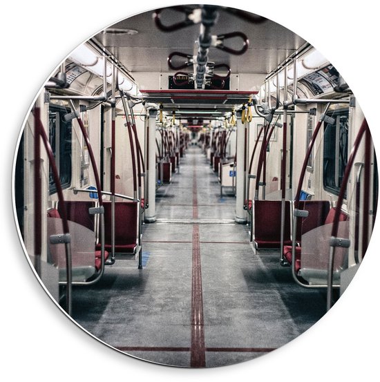 Gezicht in een metro met rode stoelen en stangen, grijze vloer met rode lijnen.