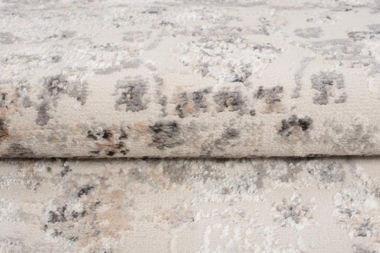 Gros plan de la texture d'un tapis gris clair aux motifs délavés et discrets.